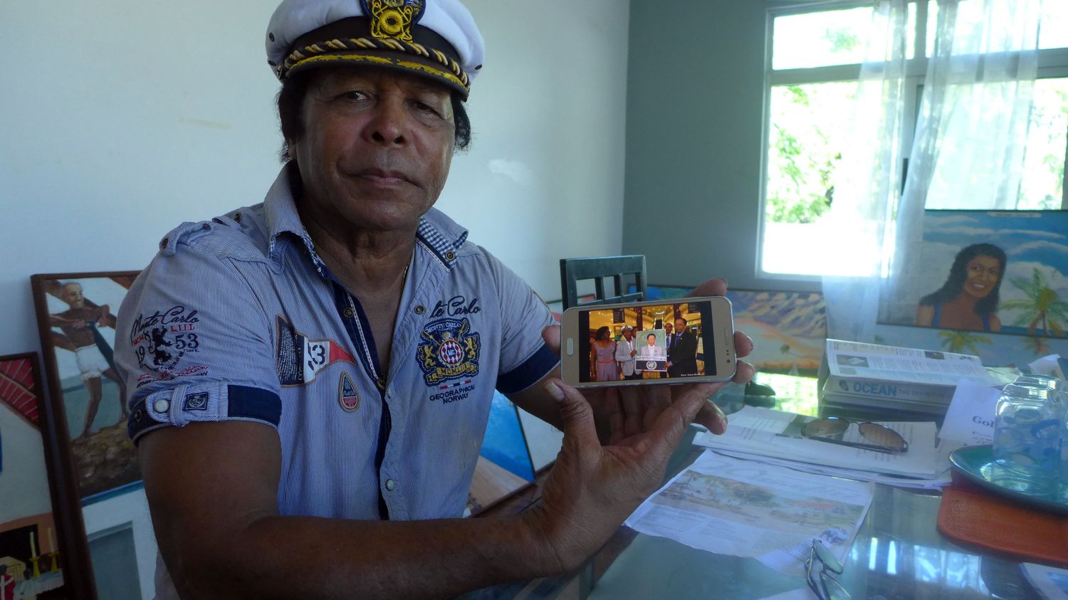 Clément SIATOUS pose avec une photo de lui et de l’ancien Premier ministre mauricien, lors de l’exposition organisée en novembre 2017.