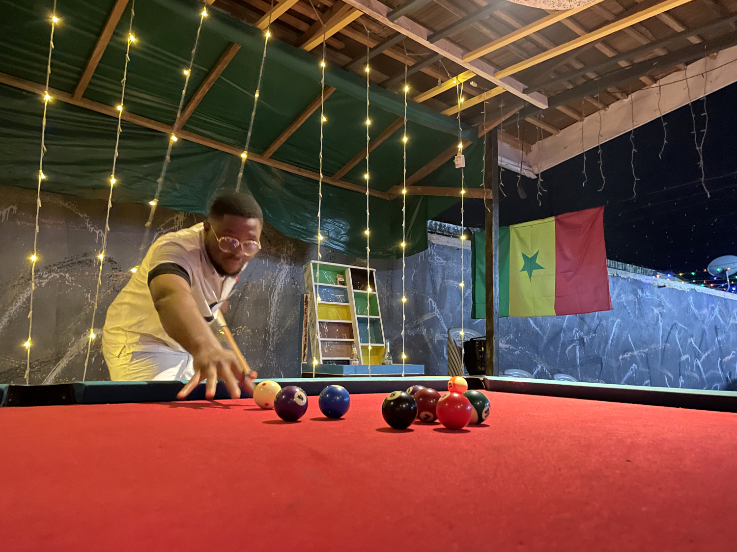 De retour d’Ebodjé, Raphaël a retrouvé Karen et Ulrich avec qui il a sympathisé autour d’une partie de billard après la défaite du Cameroun face au Nigéria en 1/8ème de finale de la Coupe d’Afrique des Nations (CAN) © Globe Reporters